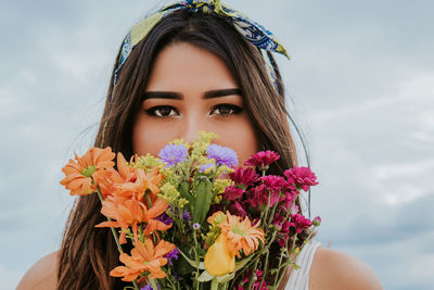 Close-up portrait of beautiful woman with red flower