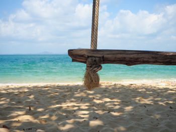 View of swing on beach against sky