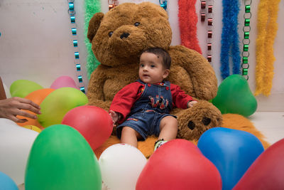 Full length of baby boy sitting on toy at home