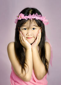 Portrait of a smiling girl over pink background