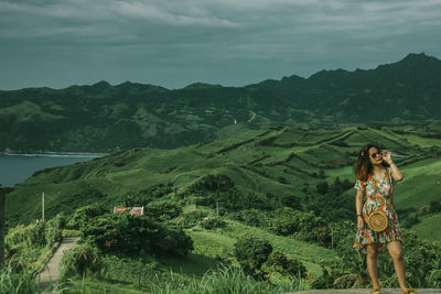 High angle view of woman standing on landscape against sky