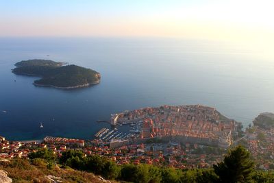 High angle view of buildings by sea against sky