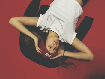 Midsection of young woman against red background