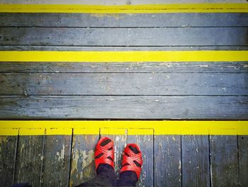 Low section of person standing on yellow umbrella