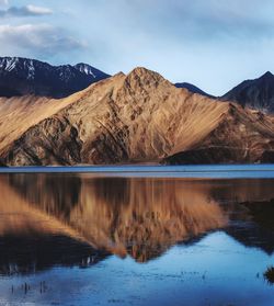 Scenic view of lake by mountains against sky