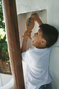 Boy eating wooden fish at home