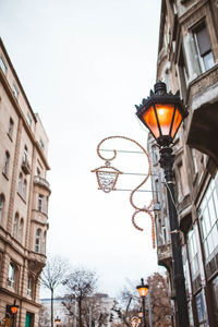 Low angle view of illuminated street light against building