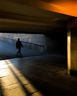 Silhouette man walking on footpath
