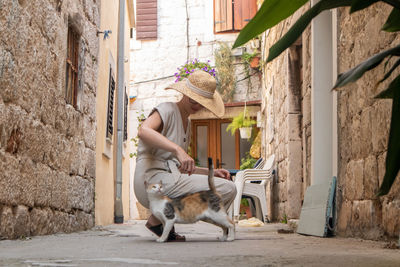 Man with dog in alley amidst buildings