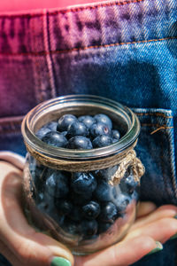 Close-up of hand holding ice cream in jar