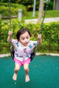 Portrait of a smiling girl on swing at playground