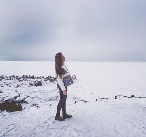 Full length of woman on snow covered land against sky