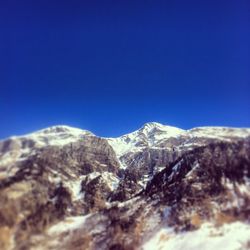 Scenic view of mountains against clear blue sky