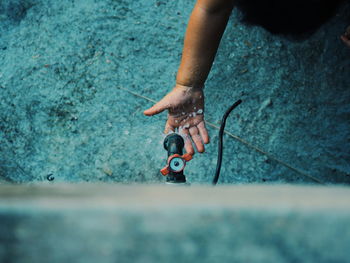 Cropped image of child washing hand at faucet