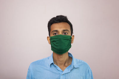 Portrait of man wearing mask against white background