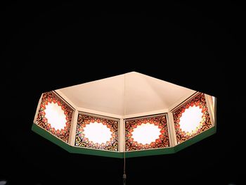 Close-up of illuminated lamp against black background