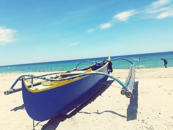 Deck chairs on beach against sky