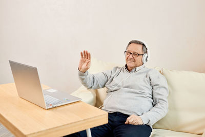 Portrait of young woman using laptop while sitting on table