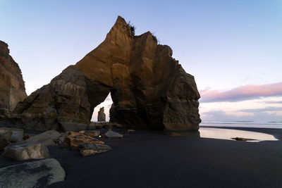 Rock formations by sea against sky