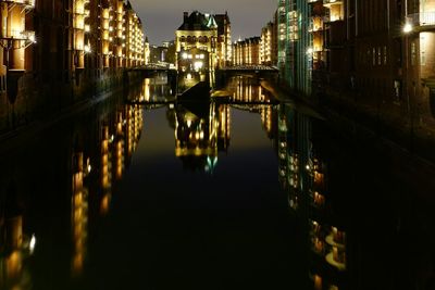 Reflection of illuminated buildings in river at night