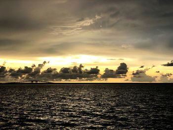 Scenic view of sea against dramatic sky during sunset