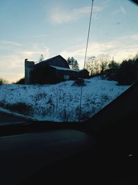 Snow covered houses against sky during winter