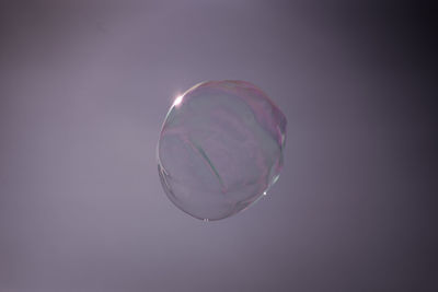 Low angle view of bubbles against purple background