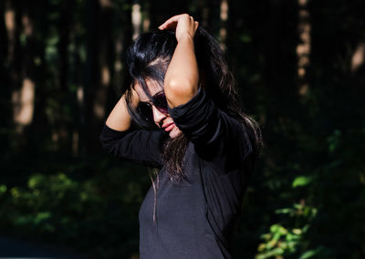 Rear view of woman standing in forest