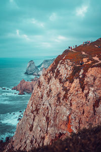 Rock formations by sea against sky