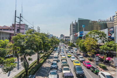 Traffic on city street by buildings against sky