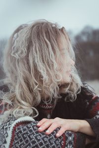 Close up curly haired woman in warm sweater outdoors portrait picture