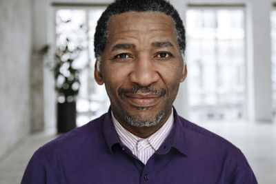 Smiling mature man in front of window