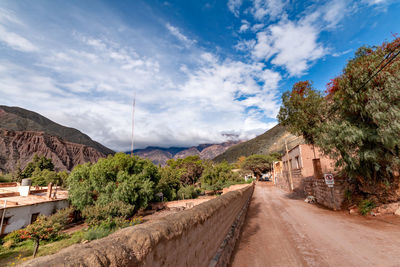 Road amidst plants and mountains against sky