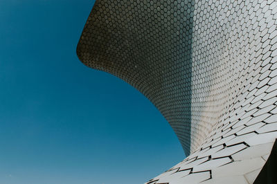 Low angle view of modern building against blue sky