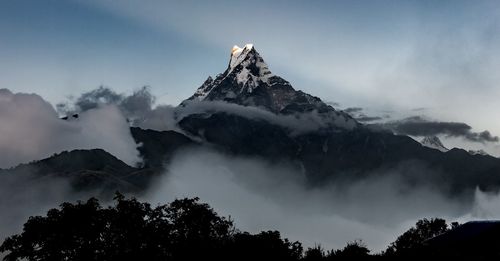 Low angle view of snowcapped mountains against sky
