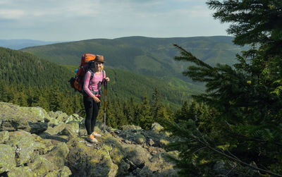 Portrait of smiling young woman standing on mountain