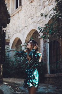 Young woman standing outside building