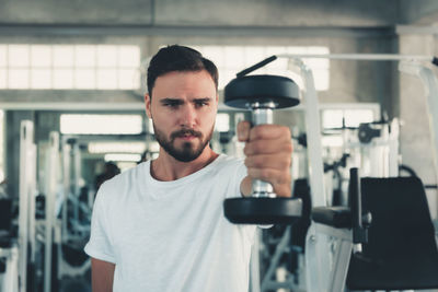 Man lifting dumbbell in gym