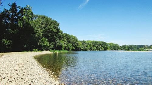 Scenic view of lake against clear blue sky