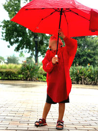 Low section of boy holding umbrella