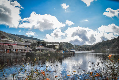 Scenic view of lake by buildings against sky