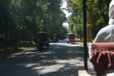 Rear view of people walking on road in city