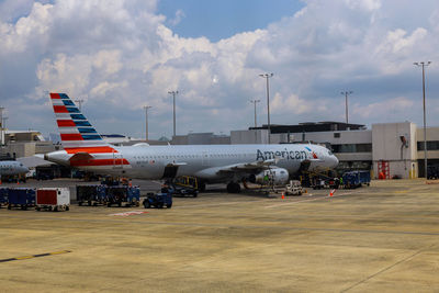 Airplane on airport runway against sky