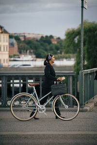 Side view of man with bicycle on street