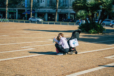 Man sitting and woman with umbrella