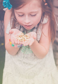 Curious girl holding star shaped glitter in cupped hands