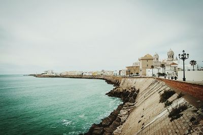 View of built structure by sea