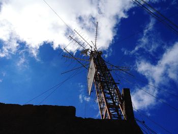 Low angle view antenna on rooftop against sky