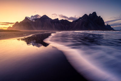 Scenic view of sea and mountains against sky