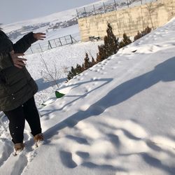 Shadow of person standing on snow covered land